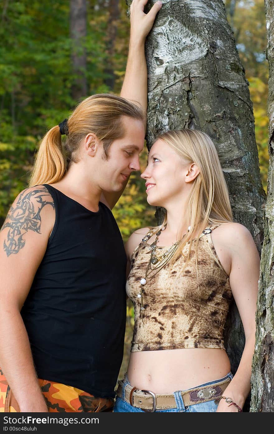 Young couple standing near tree