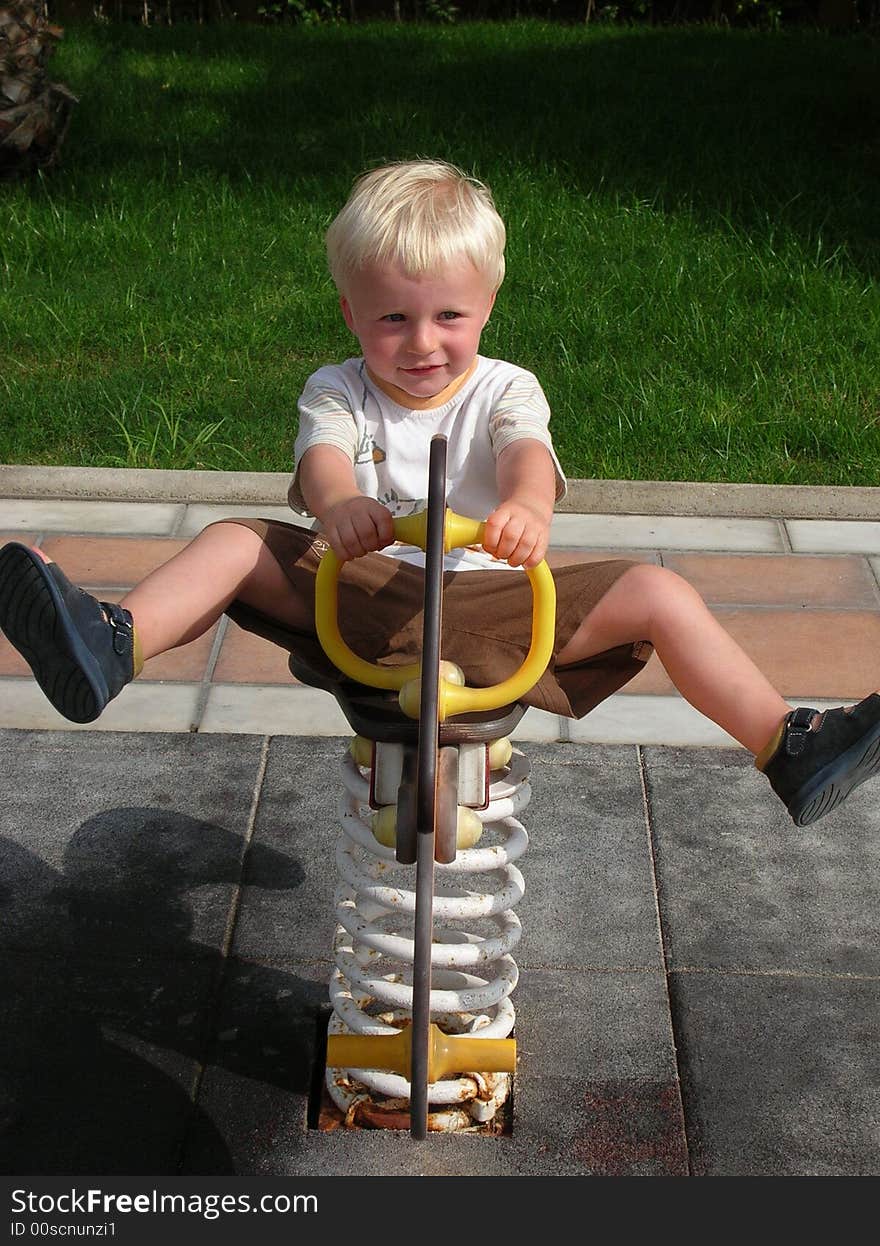 My 2-year old son marc in our holidays in spain on a playground having fun with the rocker. My 2-year old son marc in our holidays in spain on a playground having fun with the rocker