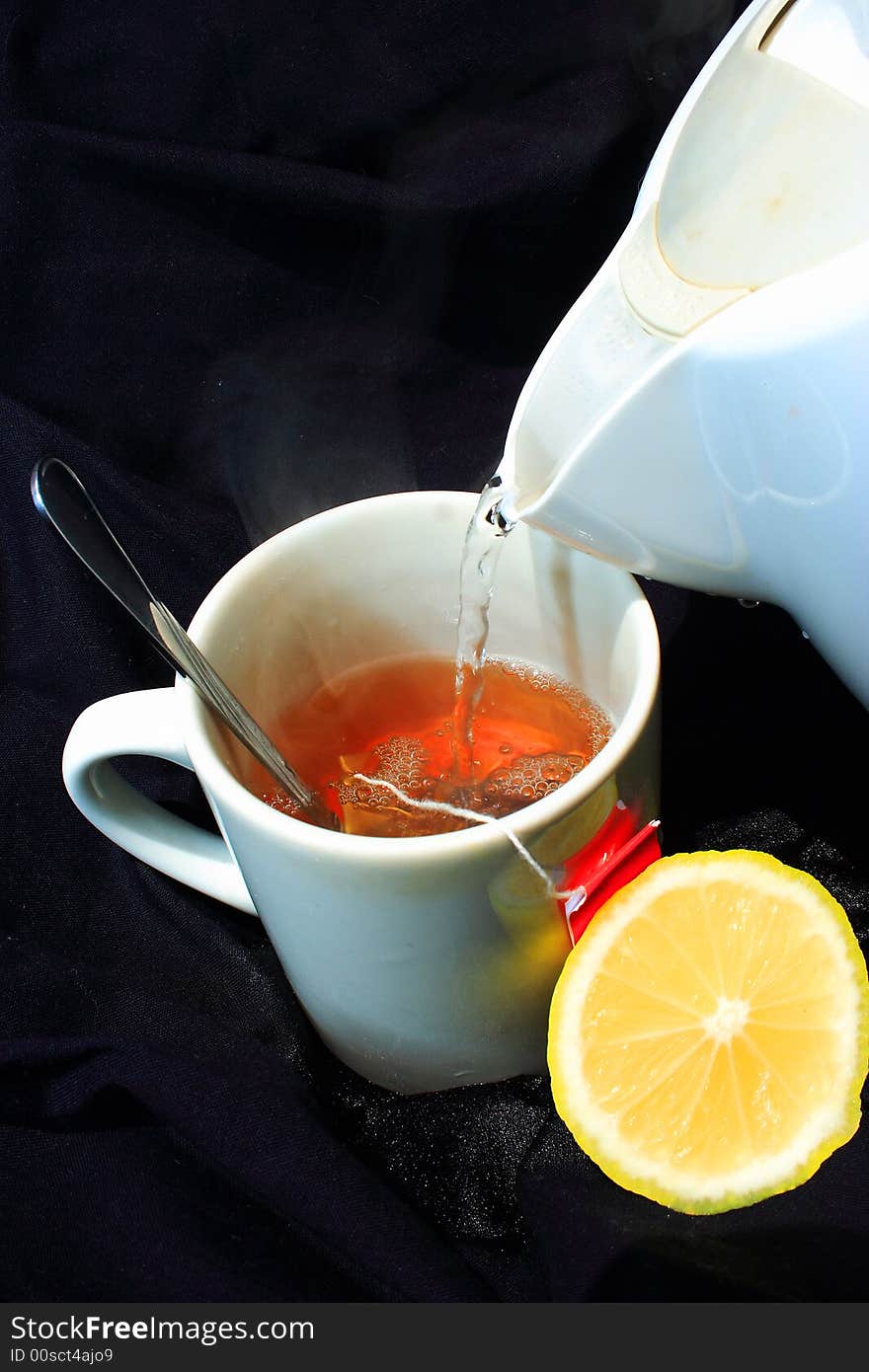 Hot tea pouring on black cloth with lemon slice taken with a Canon Eos350d digital camera. Hot tea pouring on black cloth with lemon slice taken with a Canon Eos350d digital camera