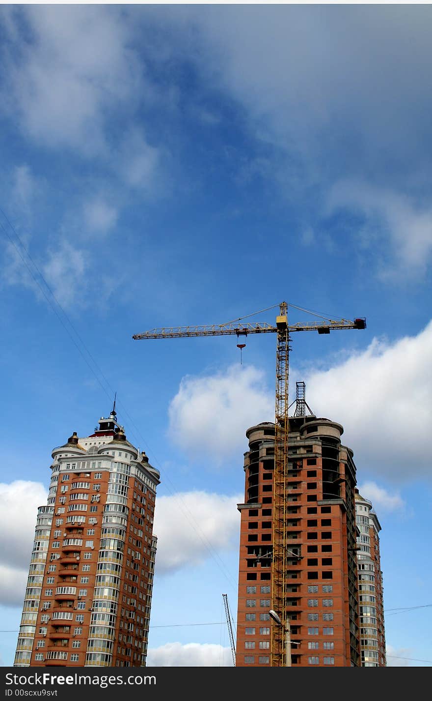 Yellow crane and two orange tall buildings. Yellow crane and two orange tall buildings