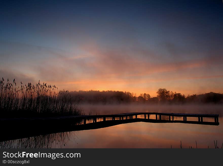 Pier and reed by lake edge