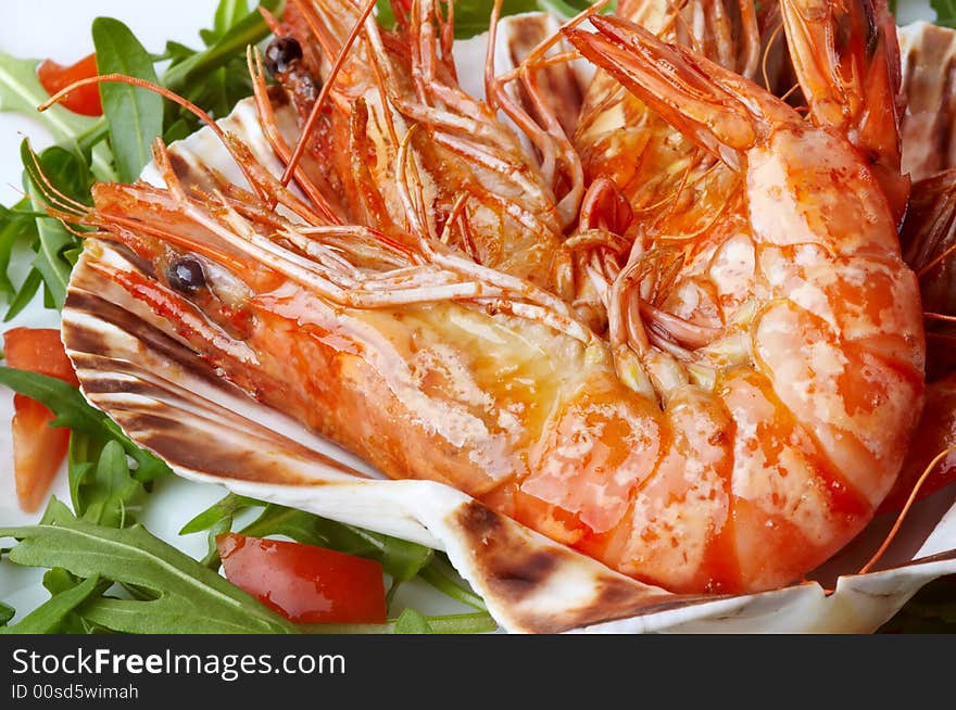 Large shrimps on shell, rocket salad and slices of tomato. Large shrimps on shell, rocket salad and slices of tomato