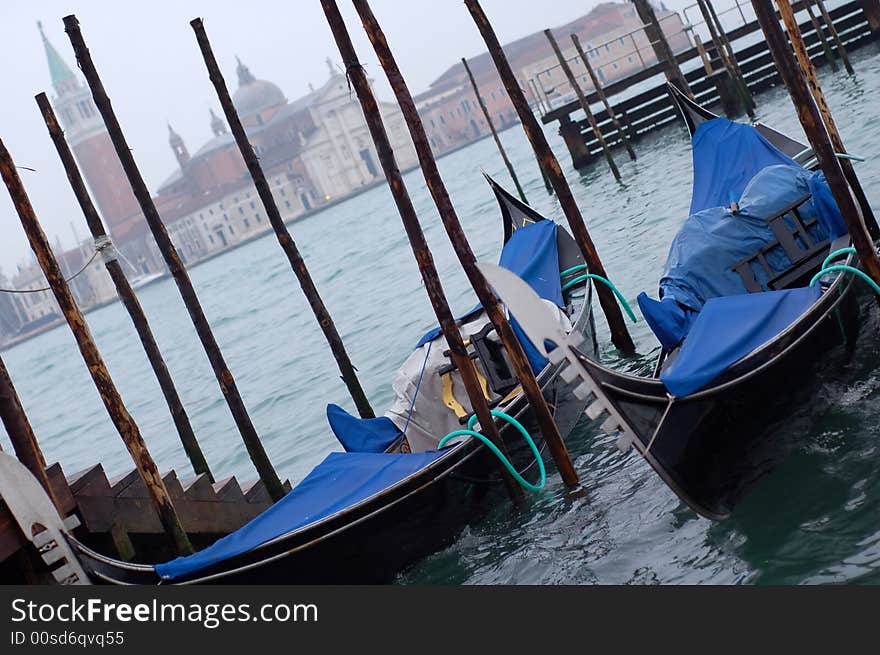 Gondolas parked in a row on canal, Venice, Veneto region, Italy. Gondolas parked in a row on canal, Venice, Veneto region, Italy.