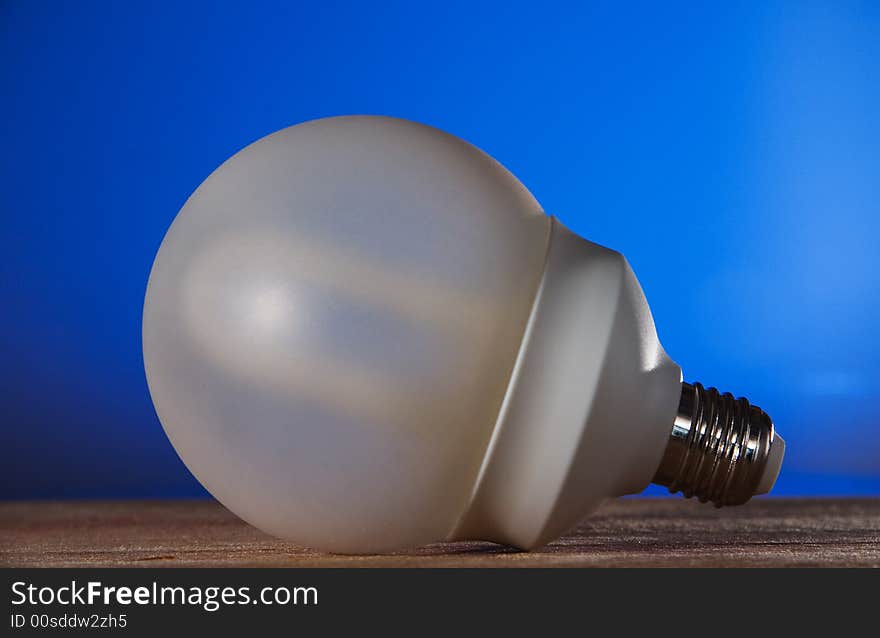 A energy saver bulb on a blue background against global warming. A energy saver bulb on a blue background against global warming