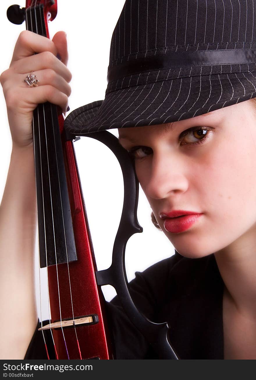 Portrait of a serios teen girl in fedora hat holding her electric guitar. Portrait of a serios teen girl in fedora hat holding her electric guitar.