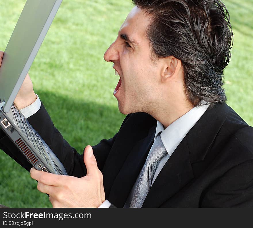 Business is very angry and screaming at his laptop. Business is very angry and screaming at his laptop