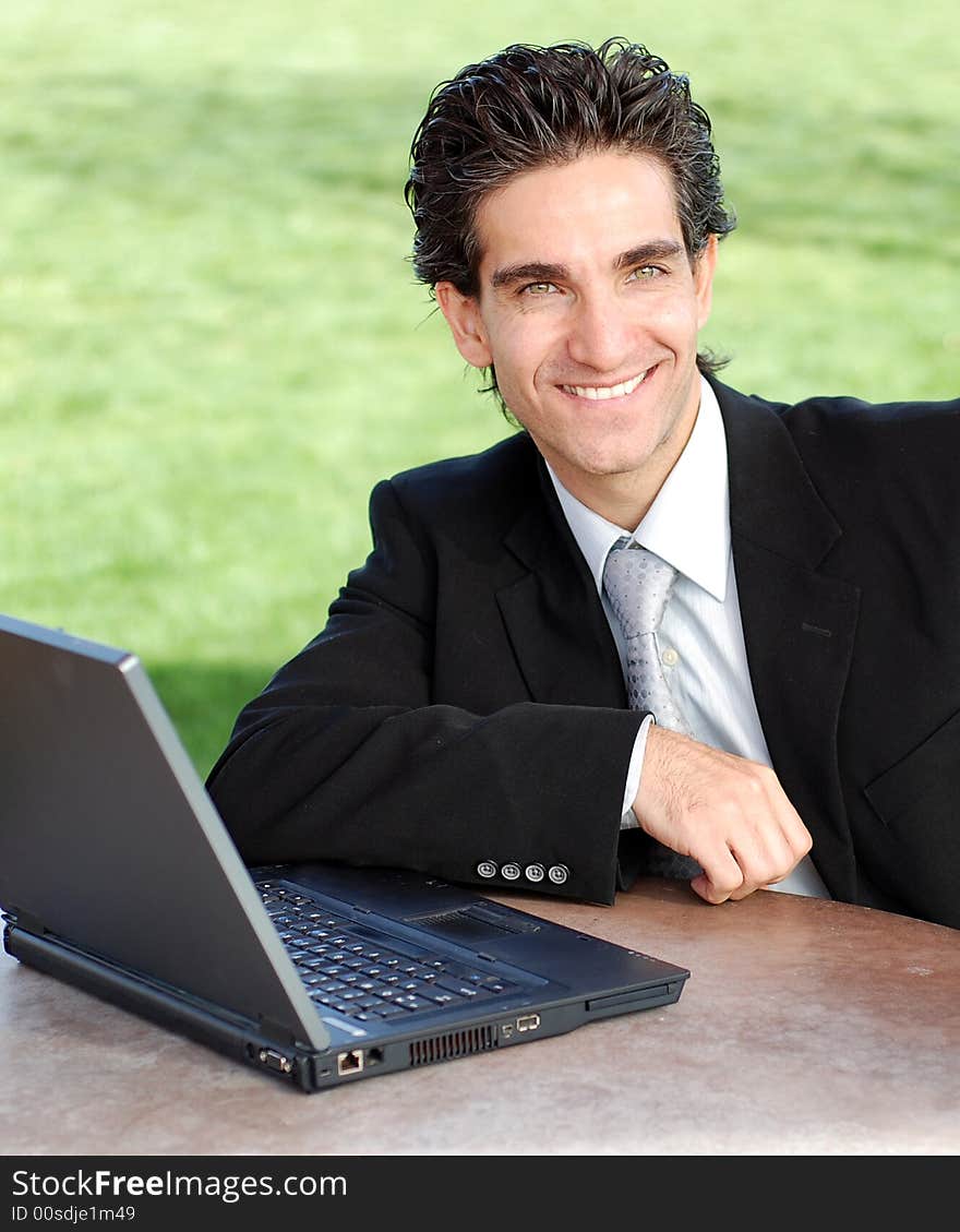 Confident and successful young adult businessman working on his laptop computer. Confident and successful young adult businessman working on his laptop computer