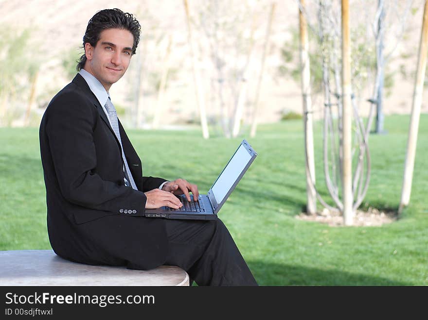 Confident and successful young adult businessman working on his laptop computer