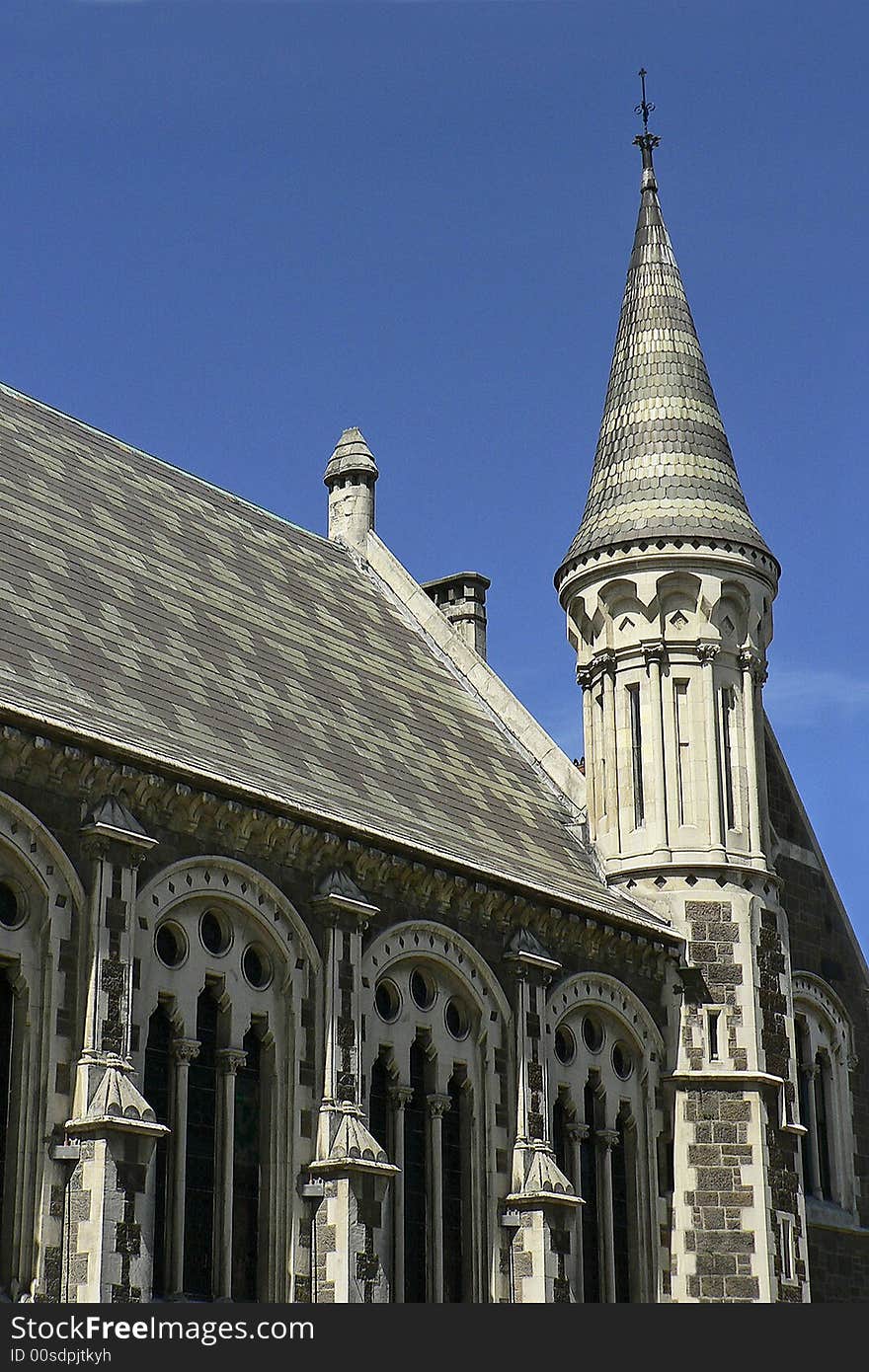 Section of the cathedral in Christchurch's Cathedral Square, showing decorative roof tiling window arches and an ornate bell tower