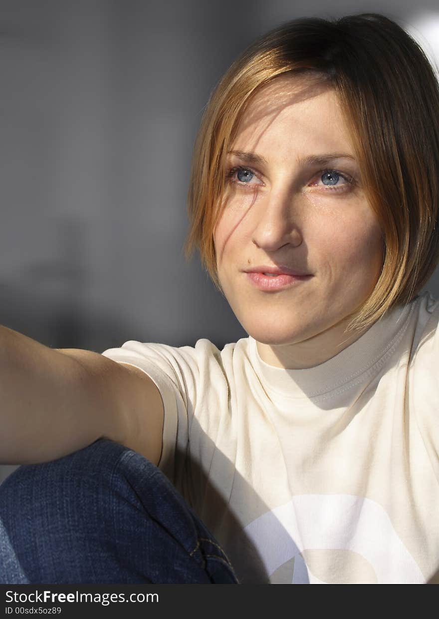 The model is relaxing by the window catching spring sun. The model is relaxing by the window catching spring sun.