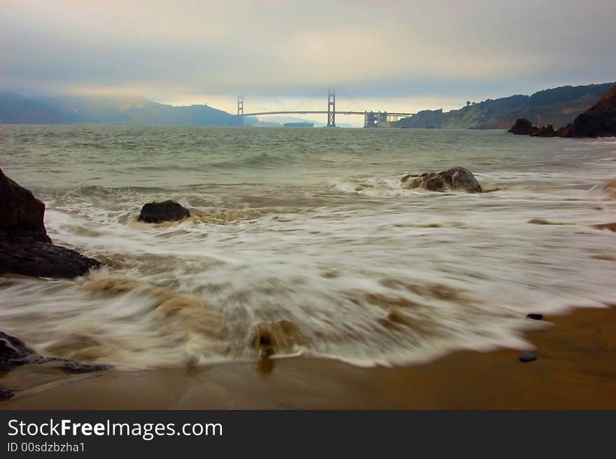 Golden Gate Bridge at sunset with waves in foreground, San Francisco. Golden Gate Bridge at sunset with waves in foreground, San Francisco