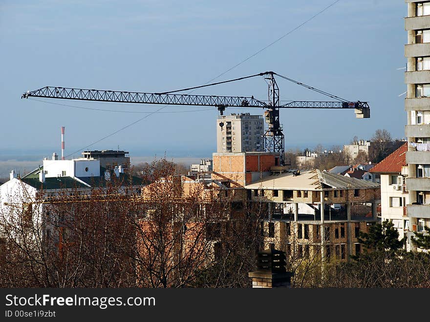 Workers on a roof of brick building with lifting crane. Workers on a roof of brick building with lifting crane