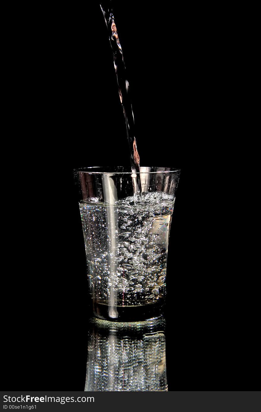 Jet of water fills in a glass. Isolated on black. Jet of water fills in a glass. Isolated on black.