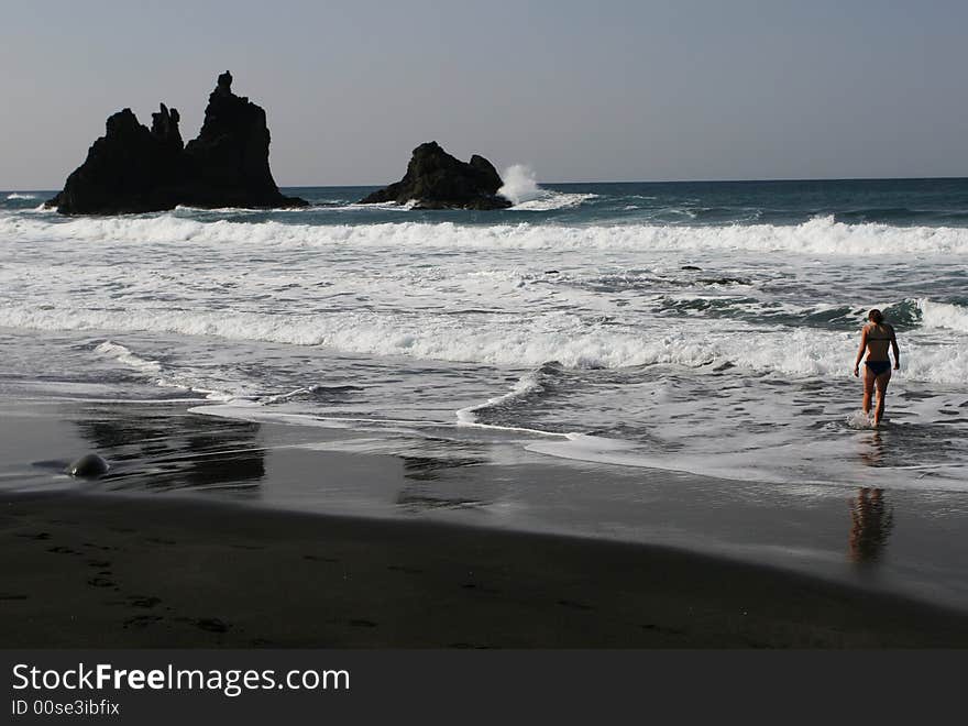 Bathing in great waves on black sand beach