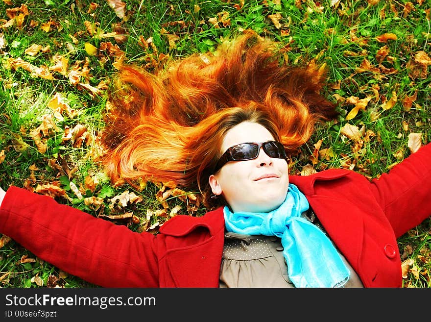 Red-haired girl laying in the grass. Red-haired girl laying in the grass.