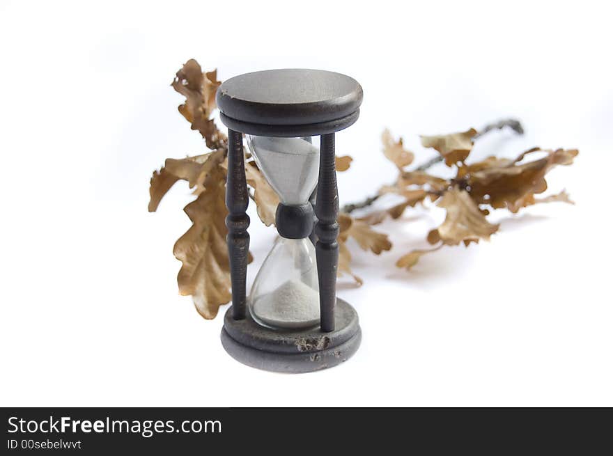 Sand-glass and fall oak on white background. Sand-glass and fall oak on white background