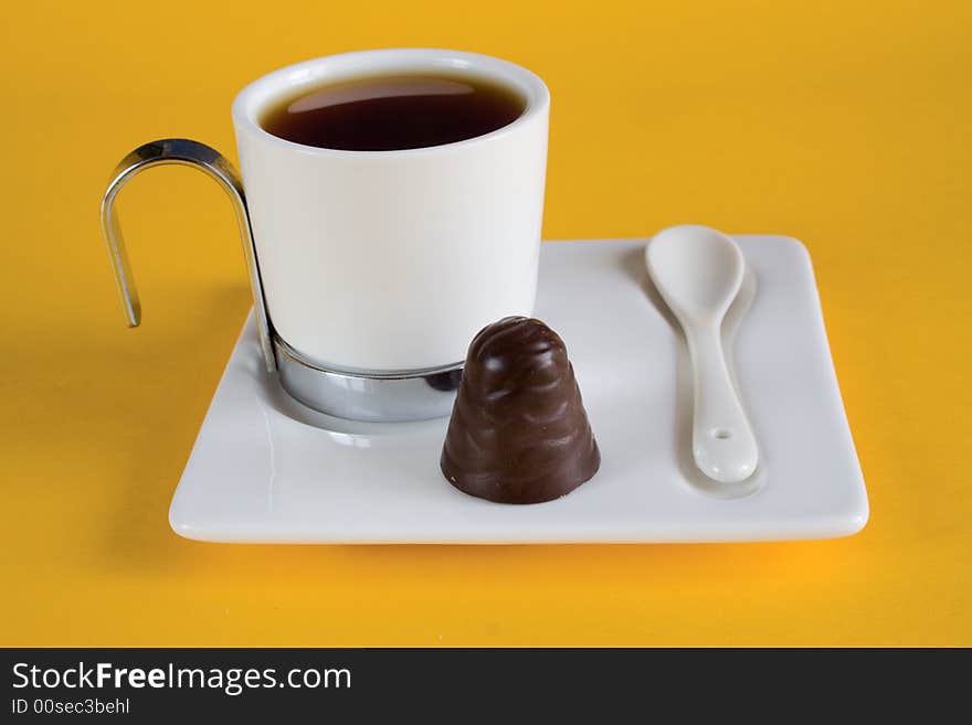 Tea has a yellow background with chocolates. Tea has a yellow background with chocolates