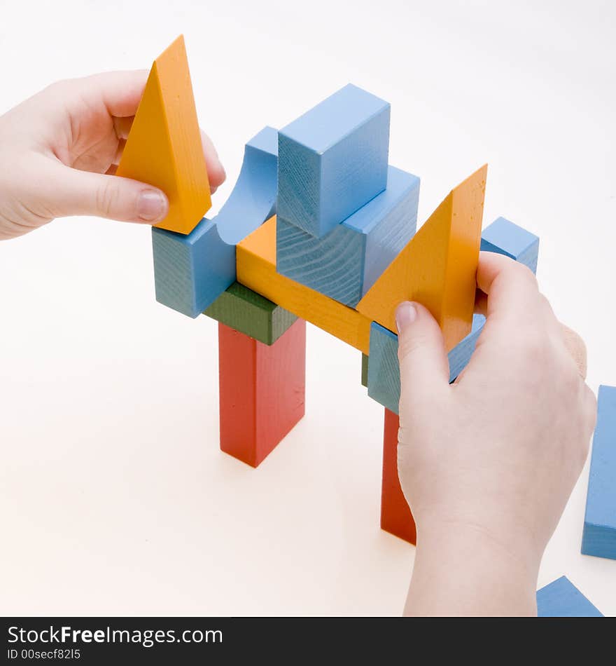 Child is playing with wooden blocks - making a building