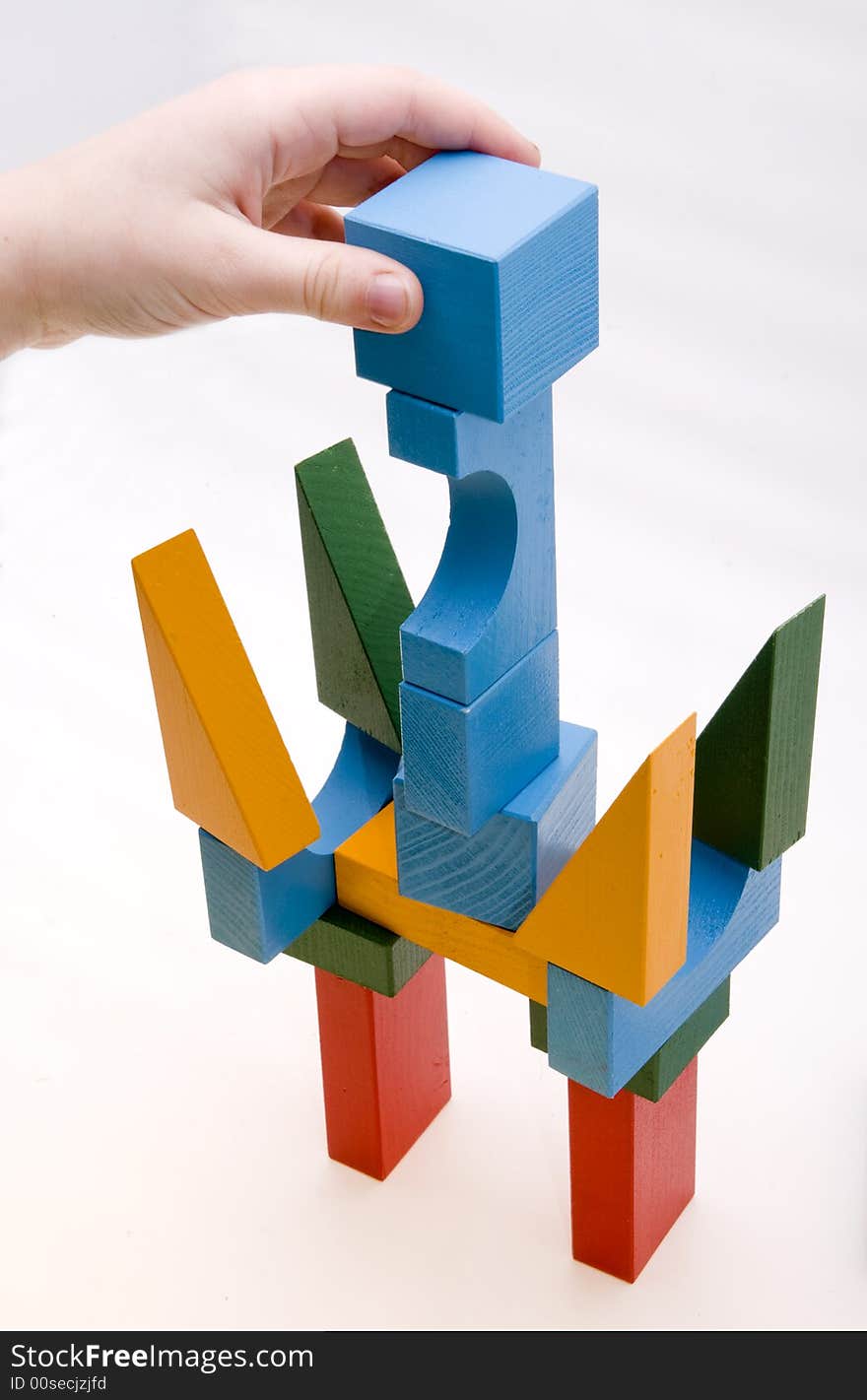 Child is playing with wooden blocks - making a building