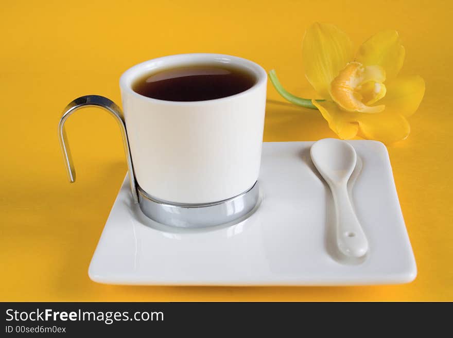 Tea has a yellow background with orchids. Tea has a yellow background with orchids