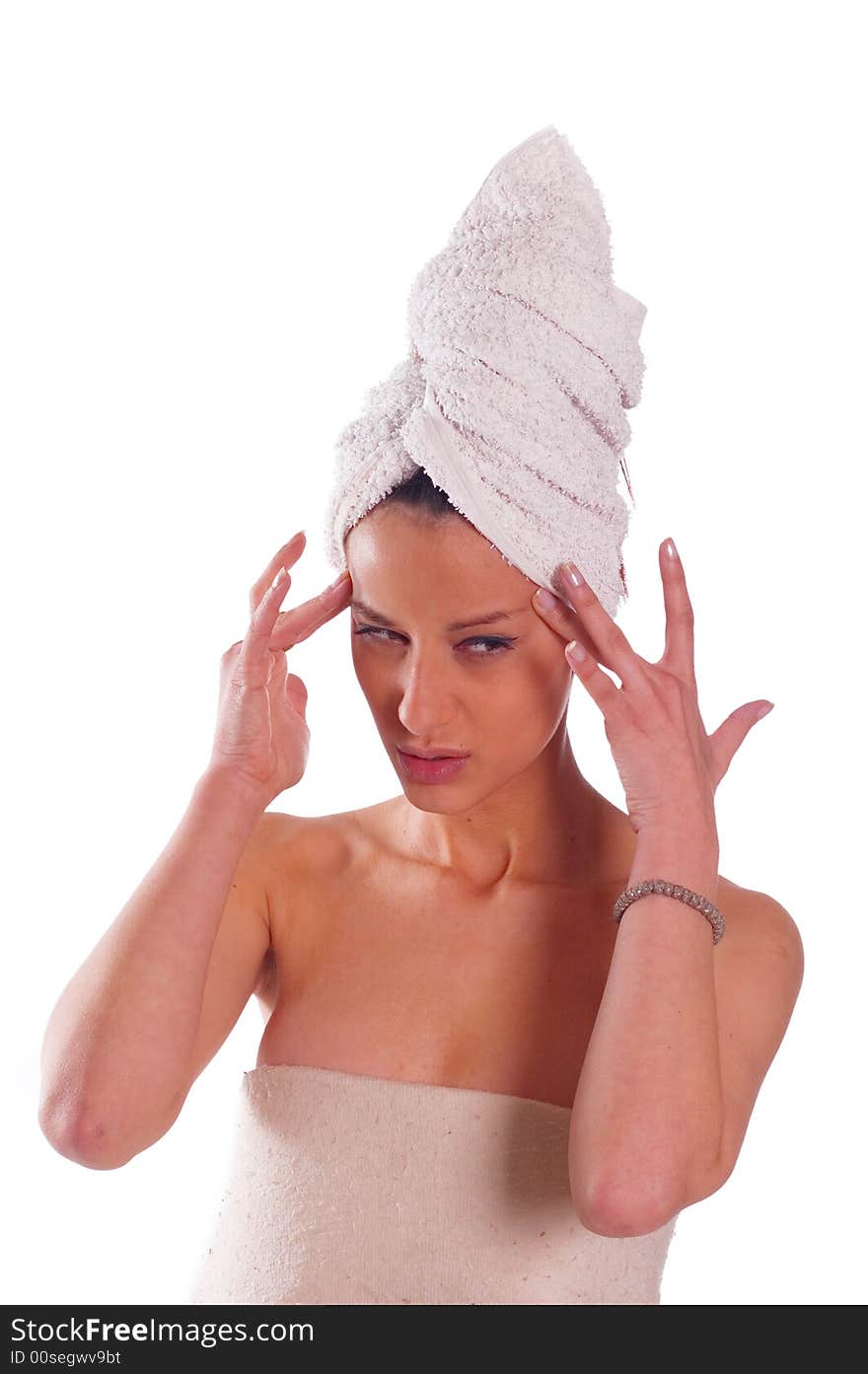 Beautiful woman with towel on her head doing massage on her forehead