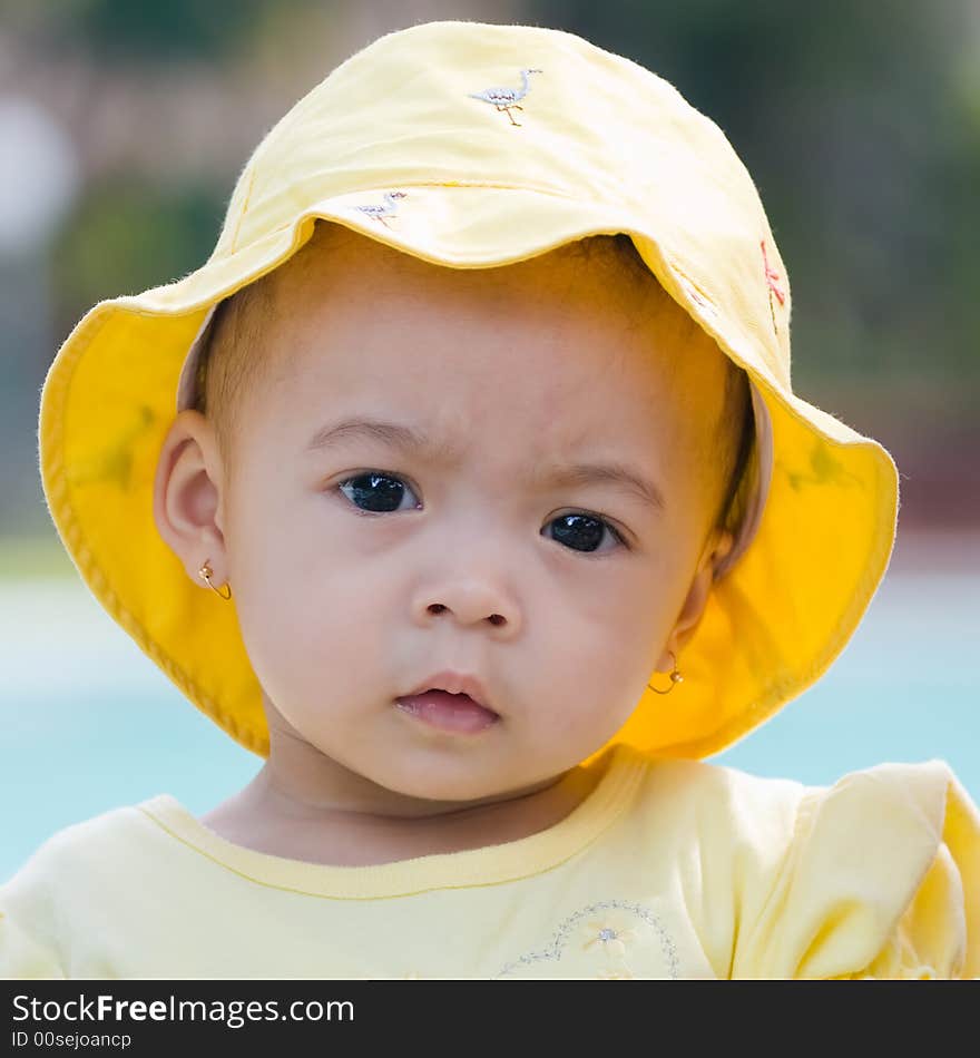 Close up photo of beautiful child wearing yellow hat