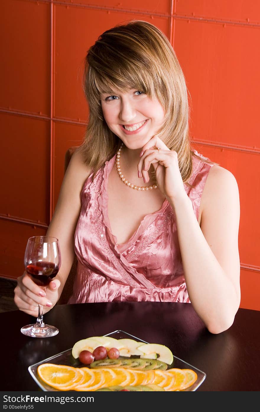 Young woman with wine glass on red background