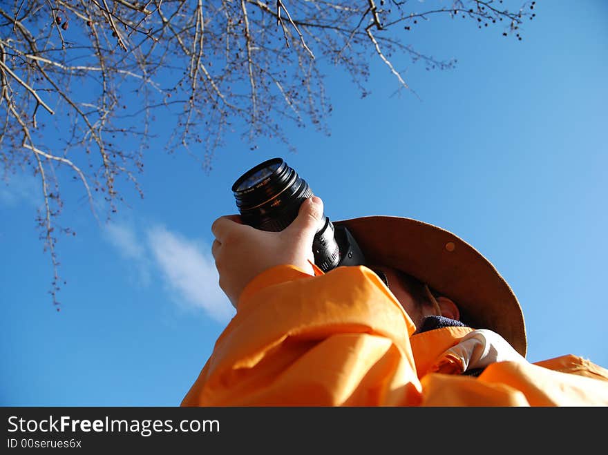 Young man taking picture outdoor, blue sky in background. Young man taking picture outdoor, blue sky in background.