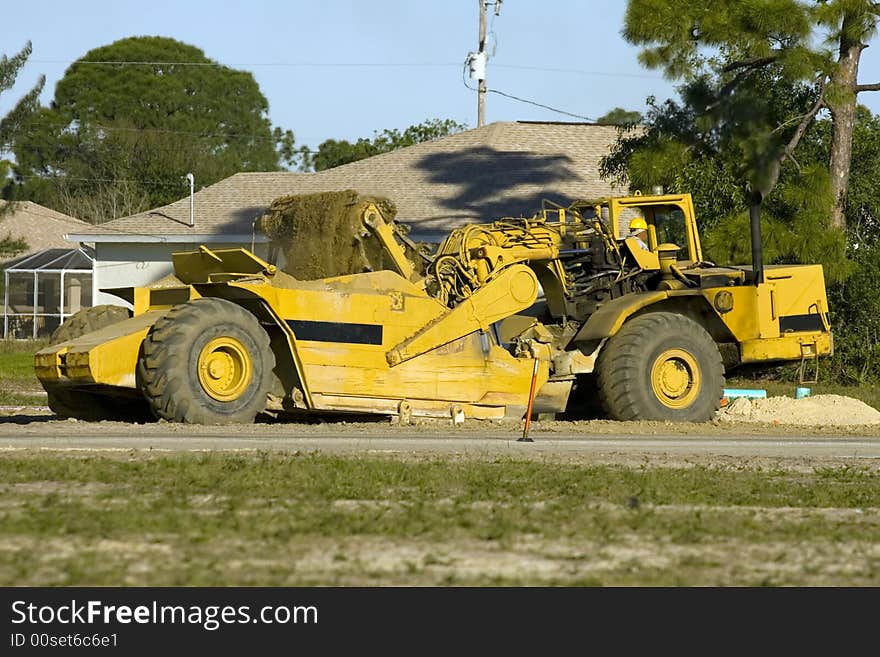 A road scrapper at work filling it's bed and moving dirt