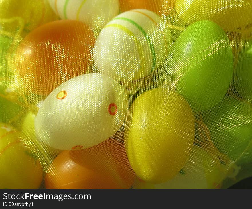 Colored little easter eggs under yellow veil