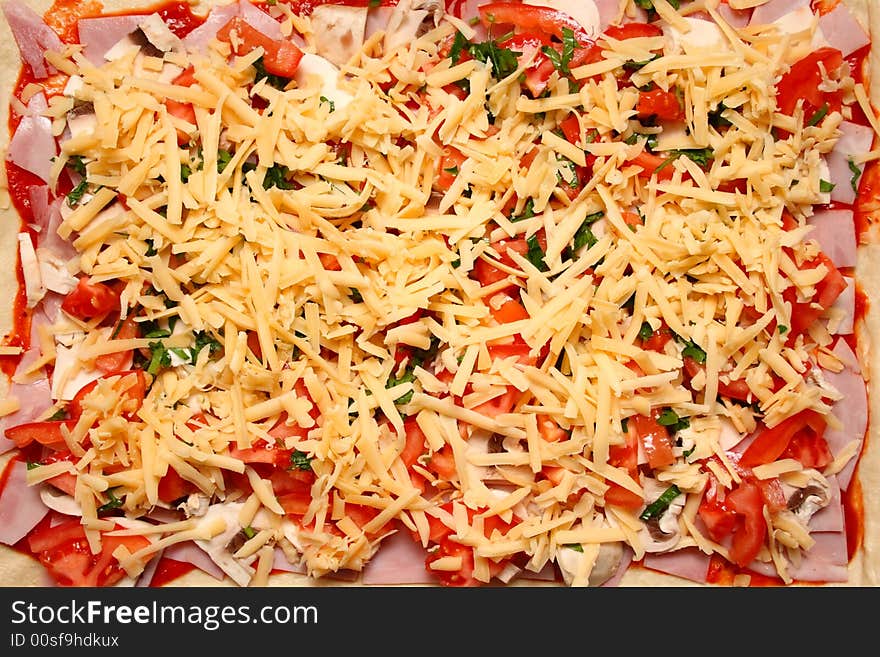 Home-made pizza with cheese, tomatos and mushrooms on baking tray. Ready for cooking. Home-made pizza with cheese, tomatos and mushrooms on baking tray. Ready for cooking