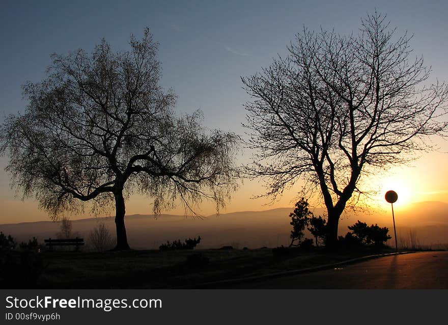 Sunset behind the silhouette the traffic sing. Sunset behind the silhouette the traffic sing