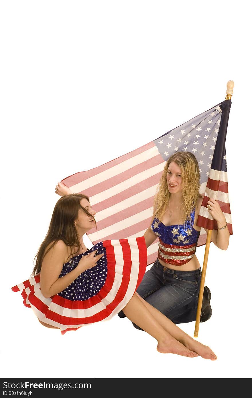 Attractive female American patriots with flag isolated over white having fun. Attractive female American patriots with flag isolated over white having fun