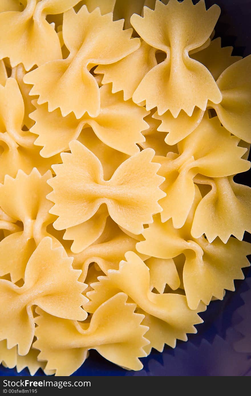 Italian pasta farfalle in the blue bowl