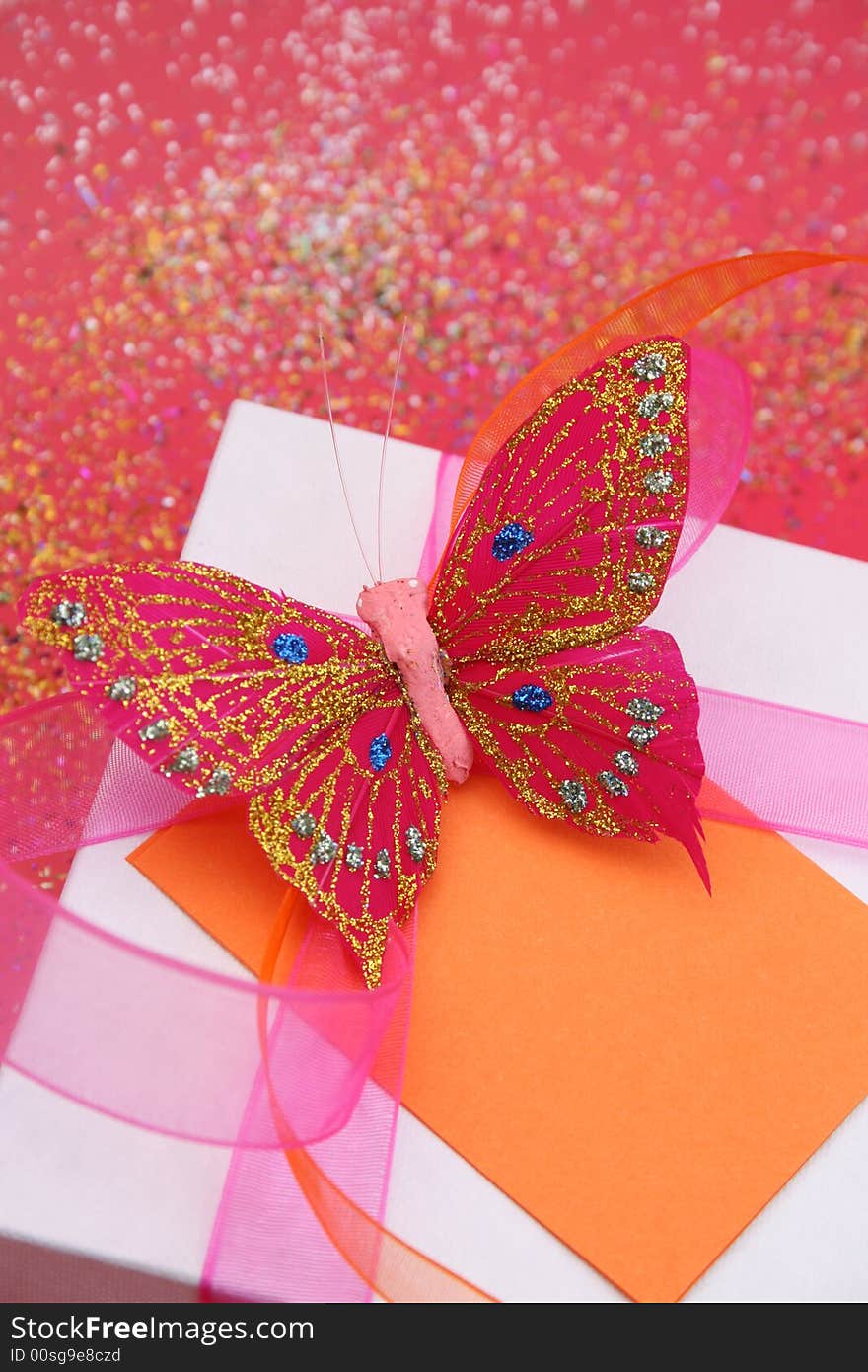 Pink butterfly on a white gift box as a decoration. Pink butterfly on a white gift box as a decoration