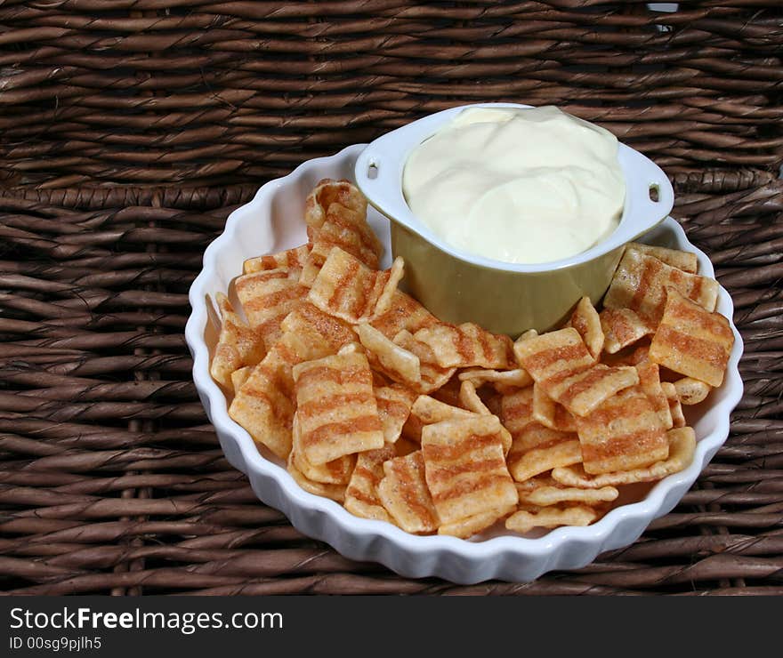 Chips in a white bowl with dip in a green bowl. Chips in a white bowl with dip in a green bowl