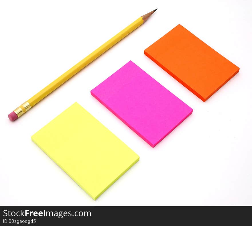 The adhesive notes besides a pencil on a white surface. The adhesive notes besides a pencil on a white surface