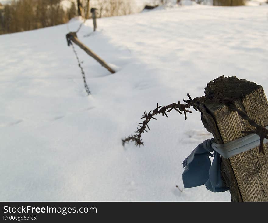 Old wooden fence with barbed wire. Winter time in mountains - Poland. Old wooden fence with barbed wire. Winter time in mountains - Poland