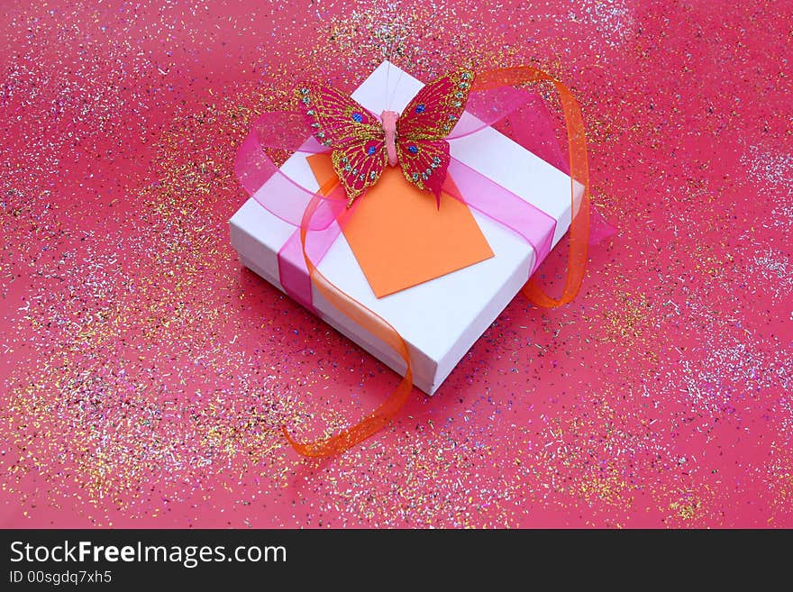 Pink butterfly on a white gift box as a decoration. Pink butterfly on a white gift box as a decoration