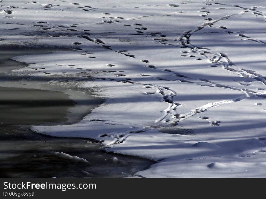 Footsteps in the snow over frozen river