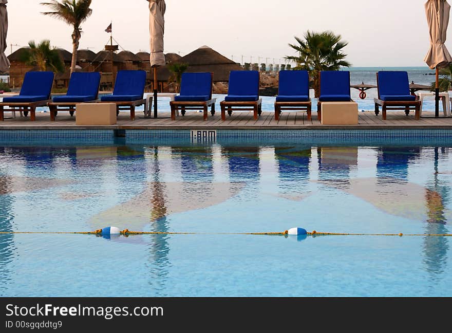 Pool in a tropical resort with beach in the horizon