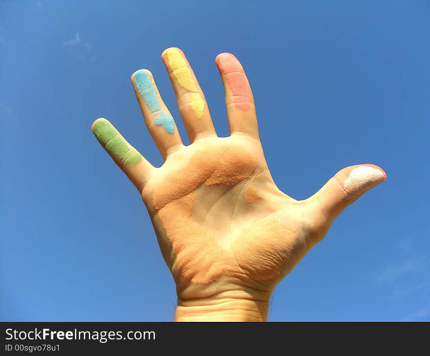 Colored hand on blue sky. Colored hand on blue sky