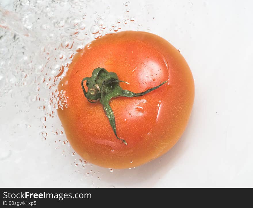 Red tomato in the water that falls. Red tomato in the water that falls