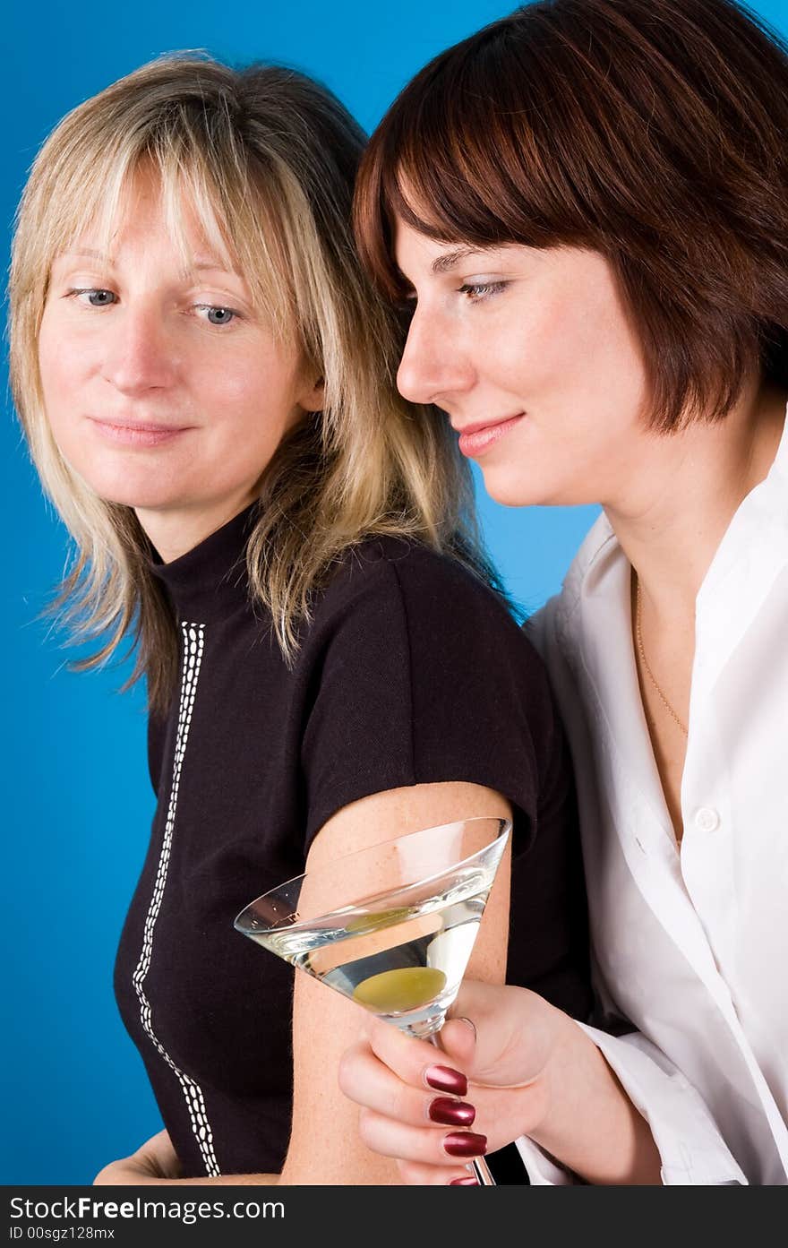 Two women with a glass of martini on a dark blue background