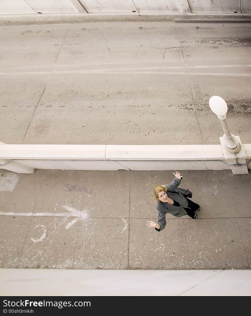 Woman On A Sidewalk With Her Hands In The Air