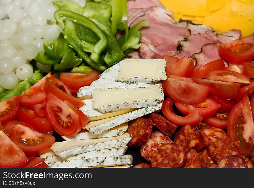 Closeup of cheese, cold meat and fresh vegetables. Closeup of cheese, cold meat and fresh vegetables