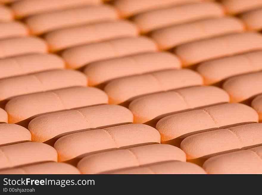 Rows of pink pills over white. Macro. Close-up