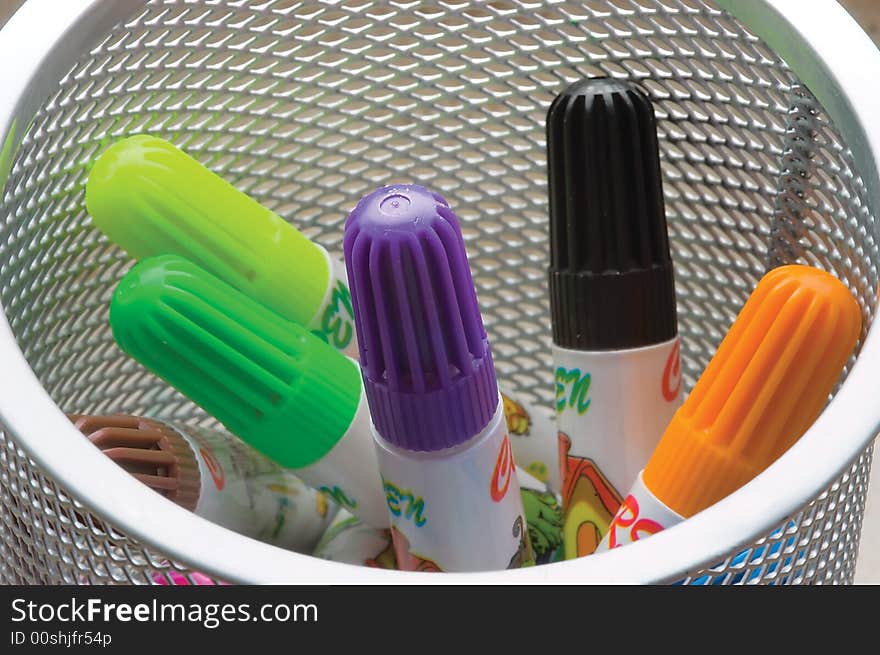 Child's felt-tip pens-markers in a white tumbler. Close-up.