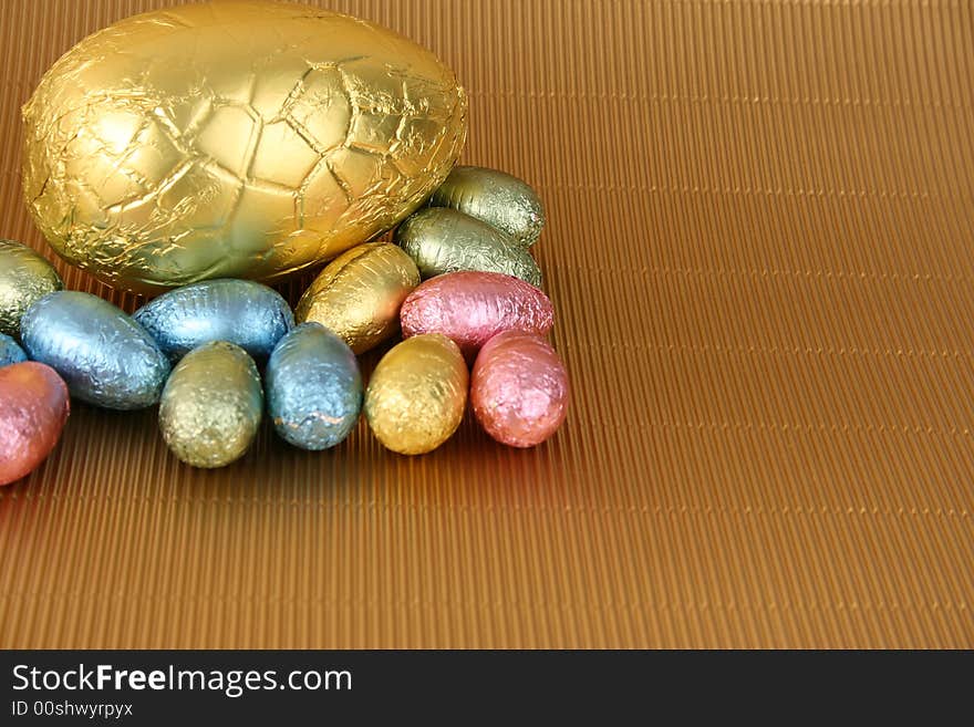 Various colors and shaped easter eggs on a gold background