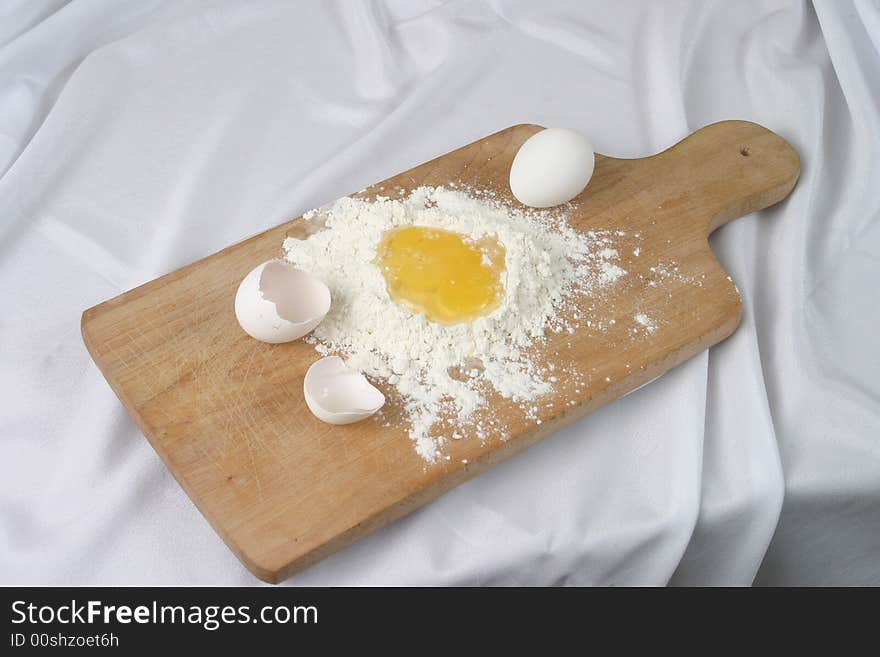 Eggs and a flour on a board